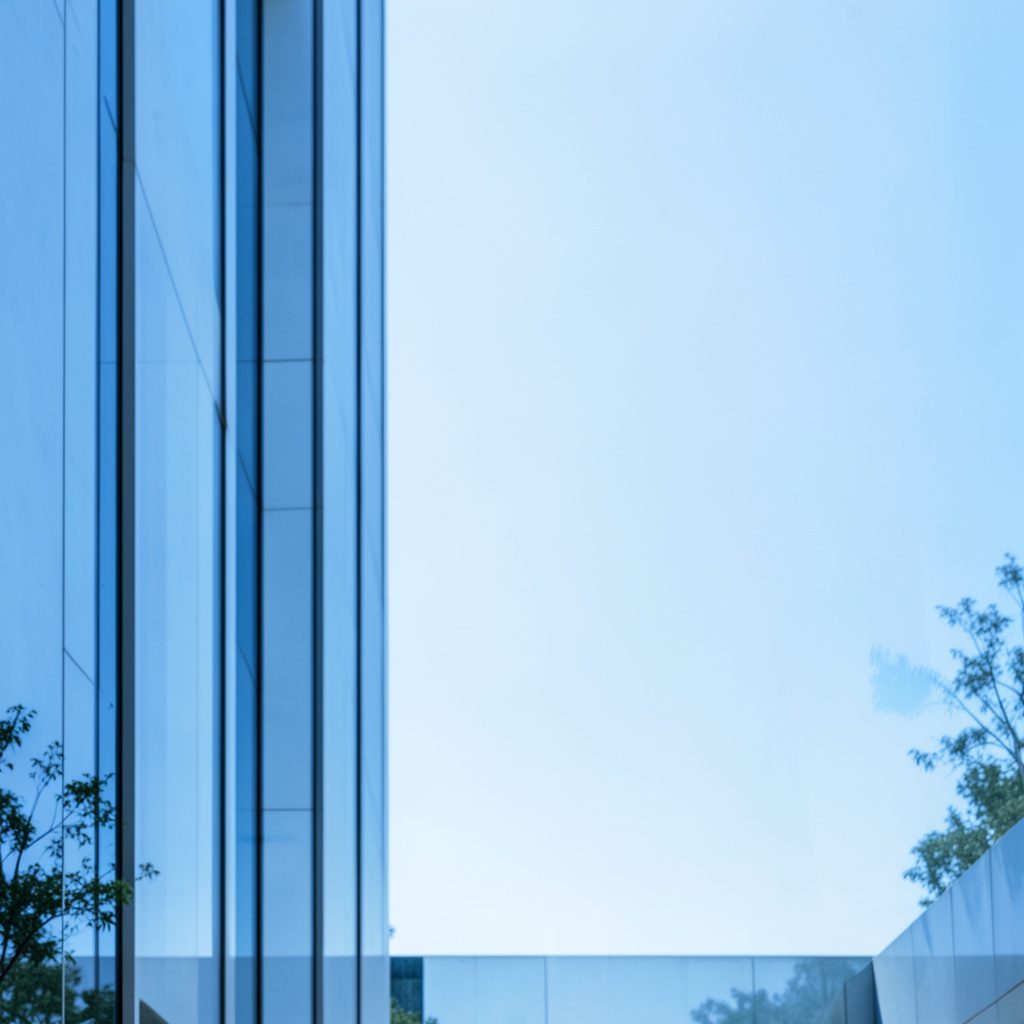 Symmetrical architectural view of a light-blue and white mission building against a pale sky, calm and welcoming.